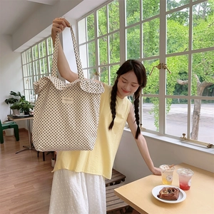 Nahaufnahme der beigen Polka-Dot Canvas Tote Bag in hellem Café mit natürlichem Licht