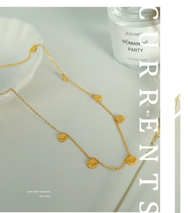 Detailed view of gold shell pendant necklace with subtle ribbed texture and fine link chain