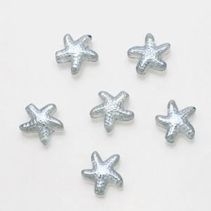 Macro detail of six grey starfish glass beads with textured facets for DIY jewelry