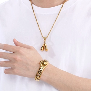 Detail view of golden boxing glove pendants on a matching necklace and bracelet set