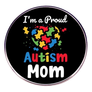 Detail view of Proud Autism Mom badge with colorful puzzle heart on black background
