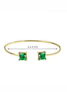 Detail shot of golden open bracelet with green square zircons showing 5.5-6.0cm diameter