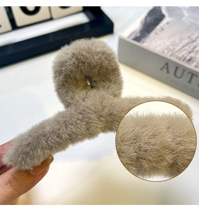 Gros plan sur la texture en peluche kaki d'une grande pince à cheveux de 14cm