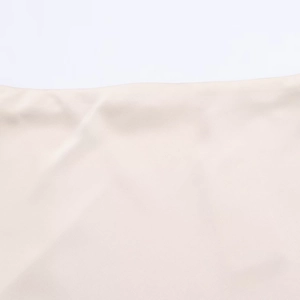 Gros plan du tissu satiné dentelle beige montrant le tissage fin et les détails de couture