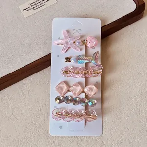 Detail of 6-piece hair clip set featuring resin starfish and pearls on a display card