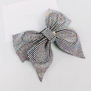 Macro shot of large bow hair clip covered in shimmering rhinestones with fine details