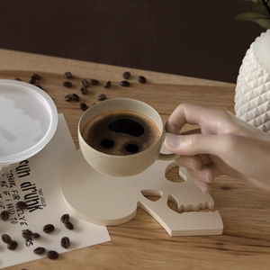 Totenkopf-Untersetzer aus Harz auf Holztisch mit Kaffeetasse in gemütlicher Atmosphäre