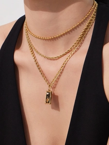 Close-up of triple-layered 18k gold plated necklace with square pearl pendant on a model