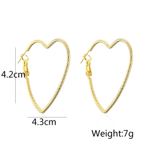 Detail view of heart-shaped gold earrings with size measurements 4.2cm and weight 7g