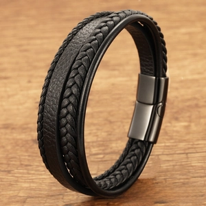 Detail of a men's layered black woven leather bracelet featuring a secure magnetic metal clasp