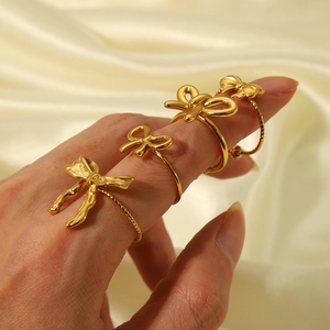 Elegant gold butterfly open rings set on silk background worn by a model