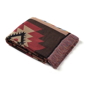 Detail of bohemian geometric woven blanket with thick texture and multicolored tassels