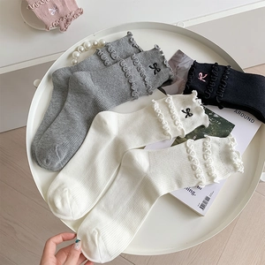 Detail of ruffled trim and bow embroidery on stylish ballet-style cotton crew socks