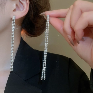 Detailansicht silberner, doppelreihiger langer Quastenohrringe mit Glitzersteinen