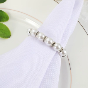 Elegant napkin ring featuring white pearls and diamond spacers on a premium white plate