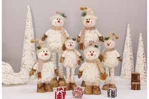 Detailed close-up of decorative Christmas snowman plush figures with gold leaf patterns