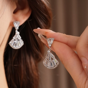 Detailed close-up of fan-shaped silver earrings with sparkling cubic zirconia crystals