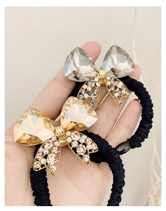 Close-up of sparkling crystal bow hair ties with rhinestones and black elastic cord