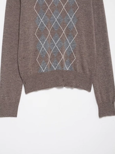 Close-up of the textured wool blend fabric and argyle pattern on the brown knit sweater