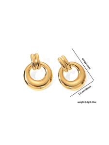 Gros plan sur des boucles d'oreilles créoles dorées avec finition miroir polie