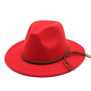 Detail of red wool felt fedora with a brown braided leather band and tassel accents