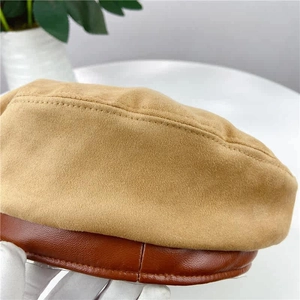 Close-up of camel suede beret with dark brown PU leather trim and detailed stitching