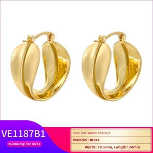 Detail of vintage gold-tone twisted leaf-shaped brass earrings with size specifications