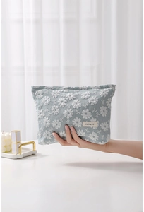 Détail de la trousse de maquillage bleue en toile avec broderie de dentelle fleurie