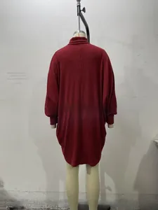 Macro view of the dark red knit dress featuring batwing sleeves and ribbed texture