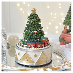 Detail of European Christmas tree music box with miniature train on a mirrored tray