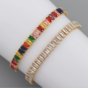 Detail of gold-plated bracelets with colorful and clear baguette-cut cubic zirconia