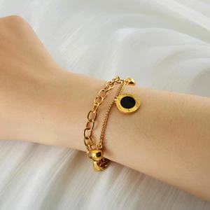 Double-layer 18K gold stainless steel bracelet with Roman numeral pendant on model wrist