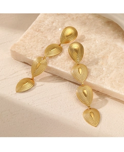 Detail of gold teardrop earrings with beaded texture and retro bohemian design