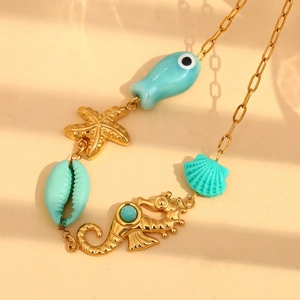 Detail of 18K gold-plated necklace with turquoise fish, starfish and seahorse charms