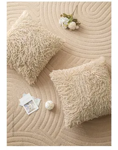 Detailed texture of plush faux fur cushion covers in cream white on a decorative rug