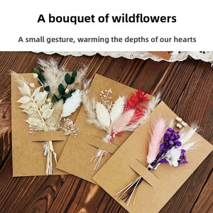 Three assorted handmade dried flower greeting cards on a dark wooden background