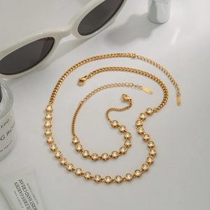 Close-up of elegant gold zircon necklace and bracelet set on a modern lifestyle desktop