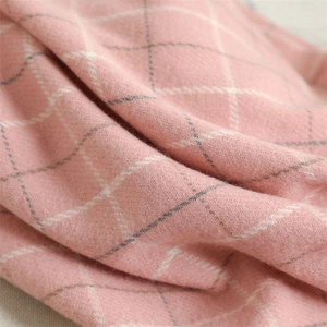 Close-up detail of soft pink cashmere plaid scarf texture with grey and white patterns