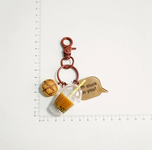 Close-up of cute milk tea and pineapple bun keychain with size scale measurement