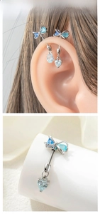 Detail of silver bow butterfly earring with blue zircon stone and drop pendant