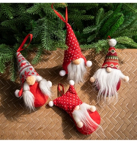 Detail of four handmade Christmas gnomes with knitted hats and festive hanging ropes