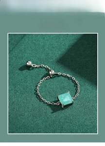Macro shot of an adjustable S925 silver chain ring with a faceted green square gemstone