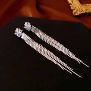 Detail of long tassel earrings with flower shaped zircon studs and snake chain drapes