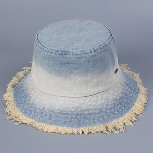 Detail of gradient denim bucket hat with fringed edges and metal logo emblem