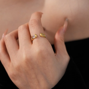 Detail of adjustable gold ring featuring a teardrop zircon and star-shaped side cutouts