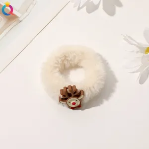 Close-up of cream fuzzy Christmas scrunchie with cute brown reindeer plush charm accessory
