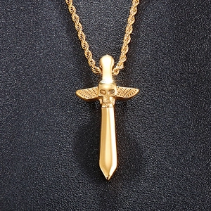Gros plan du pendentif épée tête de mort dorée avec ailes sur fond cuir noir