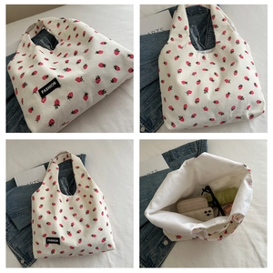 Detailed views of beige corduroy tote bag with red strawberry patterns and Fashion label