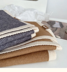 Close-up of premium knitted wool scarves in bicolor gray and brown with soft texture