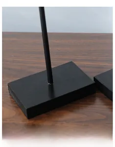 Detail of steady black wooden square base with slim metal stand for bird ornament